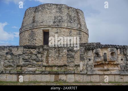 Mayapan, Yucatan, Mexiko: El Templo Redondo - der runde Tempel - mit alten Maya-Schnitzereien im Vordergrund. Stockfoto