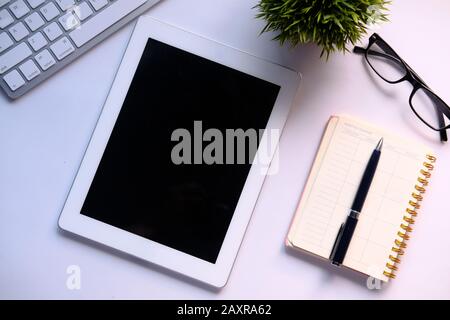 Draufsicht über digitales Tablet, Notizblock und Tastatur auf dem Tisch Stockfoto