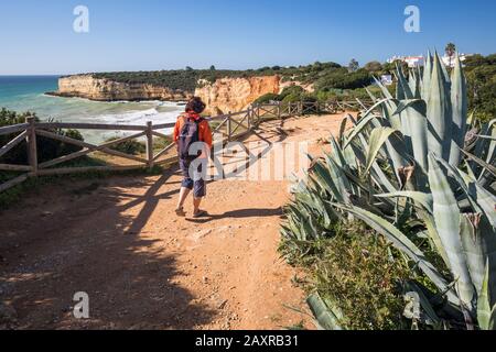 Eine Frau auf dem Klippenpfad in der Nähe von Praia Nova, westlich von Armacao de Pera, Algarve, Faro, Portugal Stockfoto