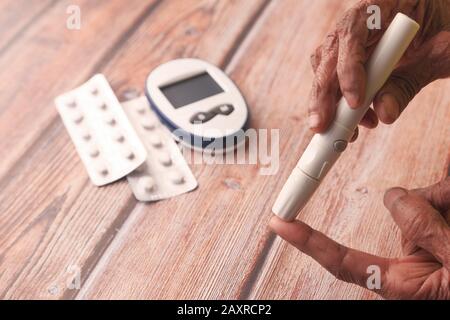 Ältere Frauen messen Diabetiker am Tisch Stockfoto