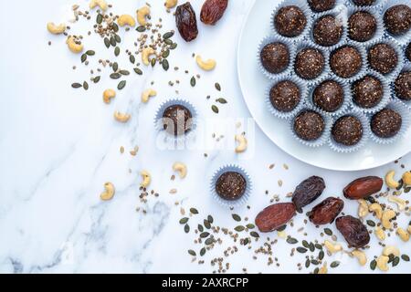 Hausgemachte vegane Kakao datieren Samen und Nuss-Energiekugeln. Hergestellt mit medjool Datteln, Cashew Nüssen, Hanf, Sonnenblumen und Kürbissamen und Kokosnuss Stockfoto
