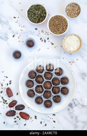Hausgemachte vegane Kakao datieren Samen und Nuss-Energiekugeln. Hergestellt mit medjool Datteln, Cashew Nüssen, Hanf, Sonnenblumen und Kürbissamen und Kokosnuss Stockfoto