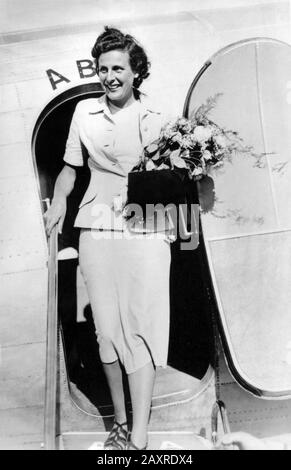 1937 , STOCKHOLM , SCHWEDEN : Die deutsche Nazi-Filmregisseure und Schauspielerin LENI RIEFENSTAHL ( 1902 - 2003 ), Freundin Adolf HITLERS, Ankunft in Stockholm auf dem Luftweg von Kopenhagen aus. Wie ein offizieller Repräsentant des deutschen Nazi-Reiches, um ihren Film "Olympia" zu präsentieren, die Dreharbeiten zu den letzten Olympischen Sommerspielen in Berlin 1936 . - NAZI - NAZISMO - NAZISTA - WW2 - 2. Weltkrieg - SECONDA GUERRA MONDIALE - DONNA REGISTA - KINO - FILM - Lächeln - sorriso - orchidea - Aeroplano - Aeroporto - Flughafen - Blumen - fiori - fiore - Borsetta - Handtasche - SVIA - Stoccolma -- - Archivio GBB Stockfoto