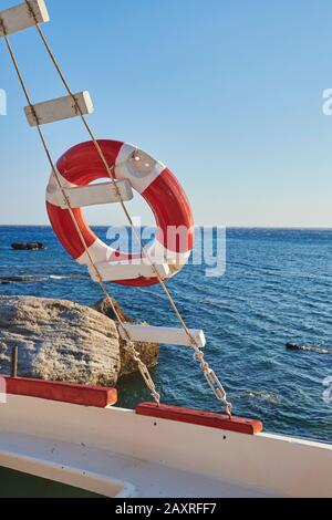 Rettungsschwimmerboje auf einer Leiter auf einem Boot an der Küste von Plakias, Crete, Griechenland Stockfoto