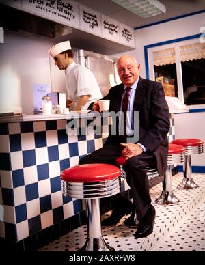 Samuel Truett Cathy (* 14. März 1921 in New York; † 8. September 2014) war ein US-amerikanischer Geschäftsmann, Investor, Autor und Philanthrop. Er gründete die Fast-Food-Restaurantkette Chick-fil-A. Cathy sitzt in einer Erholung des Café-Counters von seinem ersten Restaurant - Dem Dwarf Grill - das Teil des Chick-fil-A-Firmensitzes südlich von Atlanta, GA ist. Stockfoto