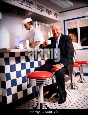 Samuel Truett Cathy (* 14. März 1921 in New York; † 8. September 2014) war ein US-amerikanischer Geschäftsmann, Investor, Autor und Philanthrop. Er gründete die Fast-Food-Restaurantkette Chick-fil-A. Cathy sitzt in einer Erholung des Café-Counters von seinem ersten Restaurant - Dem Dwarf Grill - das Teil des Chick-fil-A-Firmensitzes südlich von Atlanta, GA ist. Stockfoto