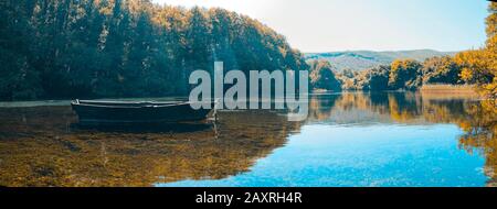 Sauberes Wasser Waldsee mit leerem Boot Stockfoto