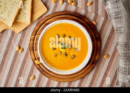 Puppkin Creme Suppe Püree, Vegetarische Diätkost auf dunkelbraunem Holztisch, Draufsicht, Nahaufnahme. Stockfoto