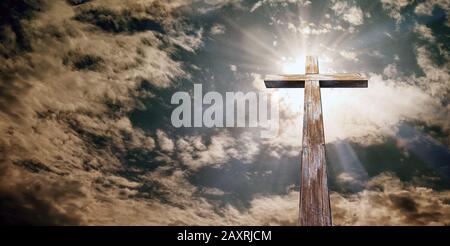 Christliches Kreuz auf dem Hintergrund des Himmels mit Wolken, Ostern. Christliches Symbol des Glaubens, 3D-Darstellung. Stockfoto