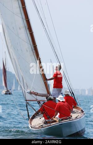 Eine alte Holzyacht mit einer vierköpfigen Crew in Rothemden, die in einer starken Brise, die auf dem Sydney Harbour segelt, Gute Geschwindigkeit macht, Gaffers Day 2011 Stockfoto