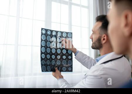 Zwei männliche Ärzte, die bei der Analyse der MRT-Ergebnisse interessiert waren Stockfoto