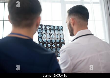 Zwei männliche Ärzte, die bei der Analyse der MRT-Ergebnisse einbezogen waren Stockfoto