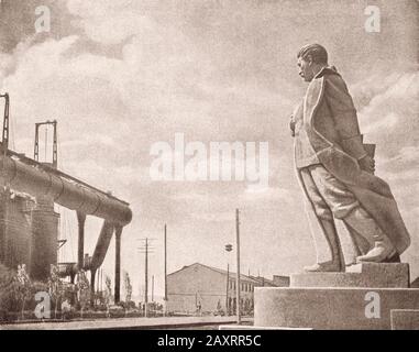 Rote Armee. Aus dem sowjetischen Propagandabuch von 1937. Denkmal für Stalin vor dem Hintergrund eines Industrieunternehmens. Stockfoto