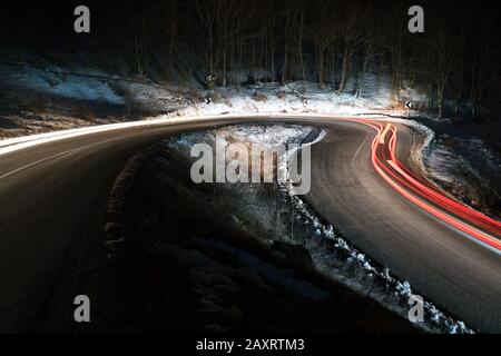 Lichter der Autos auf der Kurve der Straße an Nacht Stockfoto