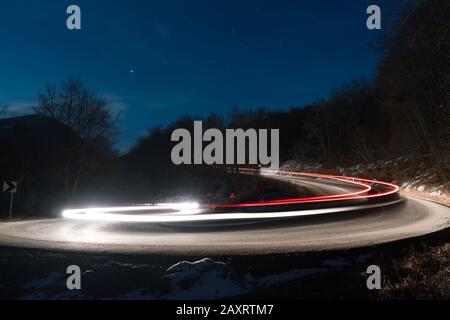 Lichter der Autos auf der Kurve der Straße an Nacht Stockfoto