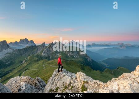 Cortina d'Ampezzo, Belluno, Venetien. Italien. Ein Kletterer am Gipfel von Ra Gusela bewundert das Panorama kurz vor Sonnenaufgang Stockfoto