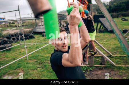 Teilnehmer Hindernisparcours suspension tun Stockfoto