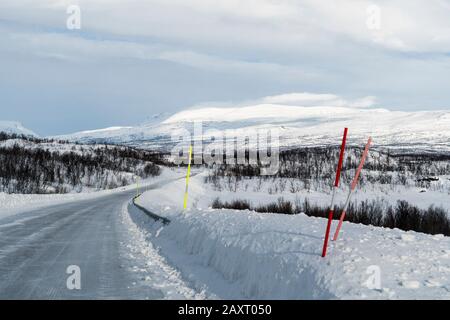 Schweden, Lappland, Winterlandschaft, Europastraße E10, gerodete Straße, Schneestangen Stockfoto