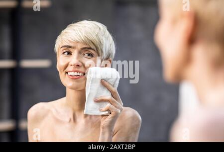 Frau Trocknet Gesicht Mit Handtuch, Das Hautpflege Im Bad Macht Stockfoto