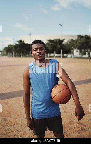 Porträt eines afroamerikanischen Basketballspielers mit Blick auf die Kamera Stockfoto