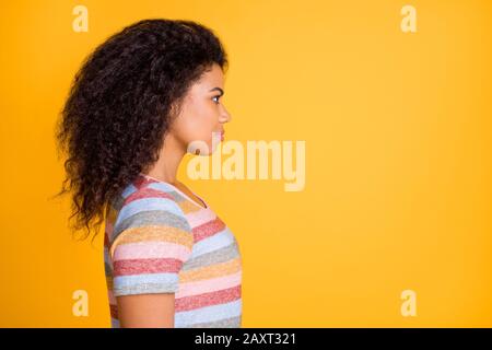 Profil Seitenansicht ihrer schönen, attraktiven Inhalte ruhig fokussiertes, wellenhaariges Mädchen mit gestreiftem T-Shirt Kopierraum isoliert auf hellem, lebhaftem Glanz Stockfoto