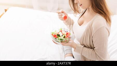 Schwangere Frau isst Salat mit frischem Gemüse Stockfoto