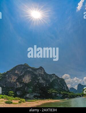Die Sonne scheint über den berühmten Gipfel Des Neun Pferdes Mural Hill am Ufer des prächtigen Flusses Li, der von Guilin nach Yangshuo, China fließt Stockfoto