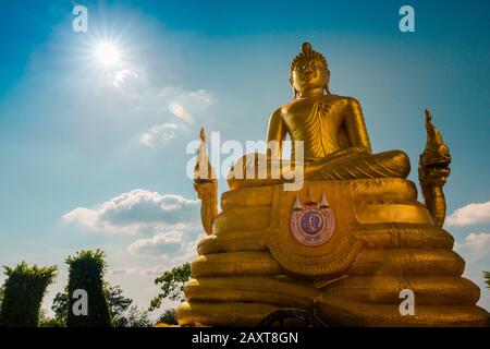 Nakkerd Hill, Phuket/Thailand-15December2019: Golden Shining Sitting buddha-statue auf dem großen Buddha-Hügel mit blauem Himmel und Wolken im Rücken Stockfoto