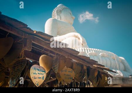 Nakkerd Hill, Phuket/Thailand-15December2019: Goldene Herzförmige Betglocken, die in einer Reihe mit spirituellen Notizen von Menschen zusammenhängen Stockfoto