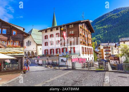 Zermatt, Schweiz - 7. Oktober 2019: Blick auf die Straße der Stadt mit Kirchturm im berühmten Skigebiet Schweizer Alpen, Menschen Stockfoto