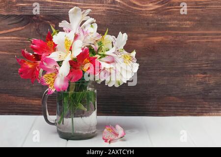 Alstromeria blüht in einem Glasbecher Stockfoto