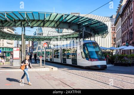 Ein Straßenbahnwagen stationiert an der Straßenbahnstation Homme de Fer, die von einer gläsernen Rotunde überragt wird, der verkehrsreichsten Straßenbahnstation in Straßburg, Frankreich. Stockfoto