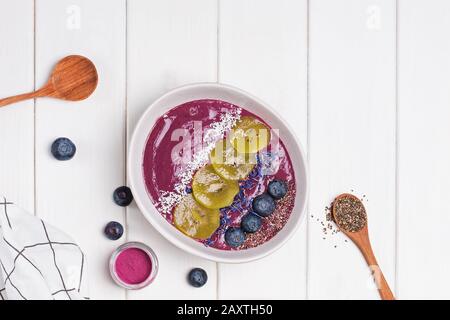 Die mit Samen, Blumen und Brombeeren bestockte Smoothie-Schüssel aus Akai-Beeren Stockfoto