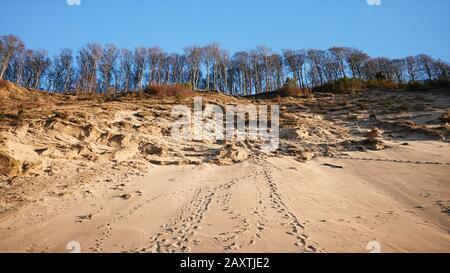 Fußabdrücke auf einer Felswand an der Ostsee bei Sonnenuntergang. Stockfoto