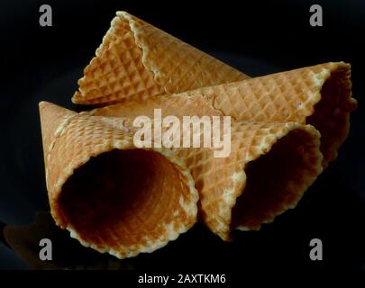 Isolierte Eiskegel. Wafermuster und Textur auf dunkelgrauem und schwarzem Plattenhintergrund. Dessert- und Süßwarenkonzept. Hintergrundbild. Kopierraum Stockfoto