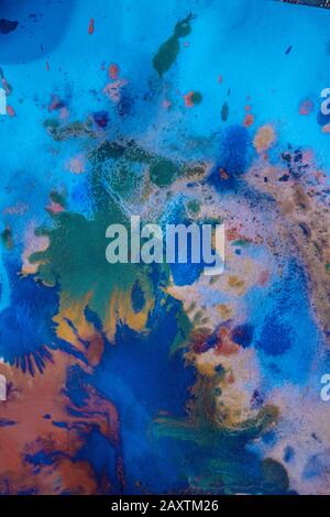 Tropfen mit Streifen unterschiedlicher Farbfarbe werden gemischt und absorbiert. Abstrakte Farbflecken auf weißem Papier Stockfoto