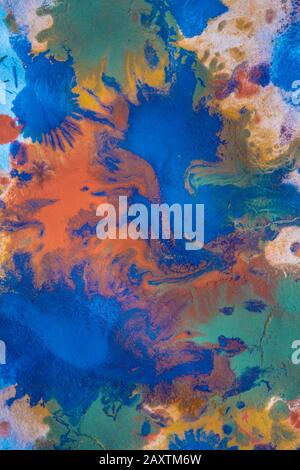 Tropfen mit Streifen unterschiedlicher Farbfarbe werden gemischt und absorbiert. Abstrakte Farbflecken auf weißem Papier Stockfoto