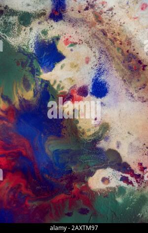 Tropfen mit Streifen unterschiedlicher Farbfarbe werden gemischt und absorbiert. Abstrakte Farbflecken auf weißem Papier Stockfoto