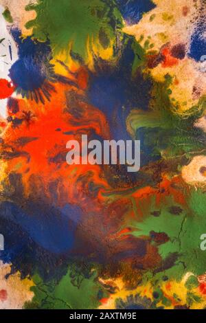 Tropfen mit Streifen unterschiedlicher Farbfarbe werden gemischt und absorbiert. Abstrakte Farbflecken auf weißem Papier Stockfoto