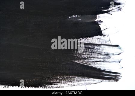 Schwarze Pinselstriche auf weißem Papier mit einer Hand isoliert Stockfoto