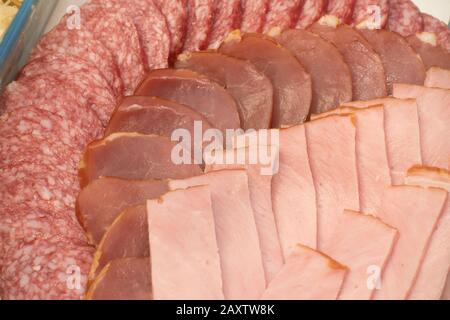 Viele Schichten der Würste von verschiedenen Sorten werden auf eine Platte gelegt Stockfoto