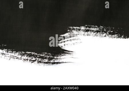 Schwarze abstrakte improvisierte Pinselstriche auf weißem Papier mit einer Hand isoliert Stockfoto