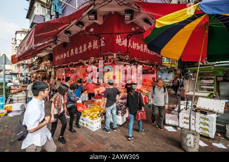 Hongkong - November 2019: Menschen kaufen Lebensmittel auf dem überfüllten Markt für Straßennahrungsmittel in Hongkong Stockfoto