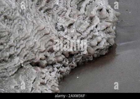 Eissand und Wasserformationen am See Stockfoto