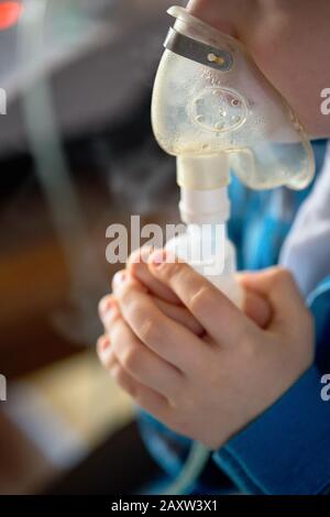 Kind macht die Inhalation zu Hause mit Zerstäuber auf unscharf Hintergrund. Beispiel der Bekämpfung von Atemwegserkrankungen wie Bronchitis tracheitis Pneu Stockfoto