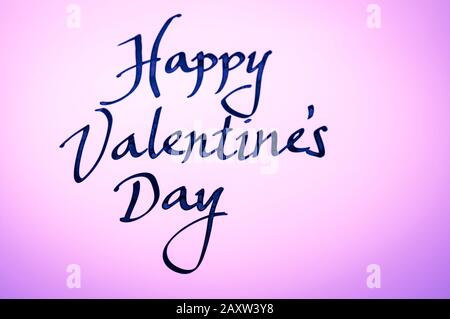 Handschriftliche Glücksbotschaft zum Valentinstag in einfacher Kalligraphie auf leuchtend pinkfarbenem Hintergrund Stockfoto