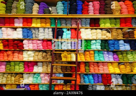 Regale mit bunten Wollgarnspulen in einem Strickladen Stockfoto