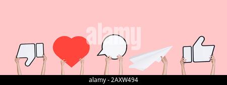 Hände, die die Zeichen sozialer Medien auf Korallenhintergrund halten, Flyer. Copyspace für Text oder Bild, Werbung. Anzeigen von Bedeutung, Gadgets, modernen Technologien, Kommentaren, Nachrichten, Interaktionen. Stockfoto