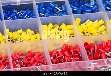 Details zum Kabelend-Kit für Aderendhülsen im Raster der Kunststoffbox. Isolierte Kupfer-Crimpsteckverbinder in Werkzeugkasten. Crimpwerkzeuge. Stockfoto