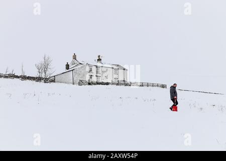 Upper Teesdale, County Durham, Großbritannien. Februar 2020. Wetter in Großbritannien. Eine Person hat die unbeneidenswerte Aufgabe einer langen Grabung, um den Weg zu ihrem Haus zu räumen, damit sie ihr Autokredit ausziehen: David Forster/Alamy Live News Stockfoto